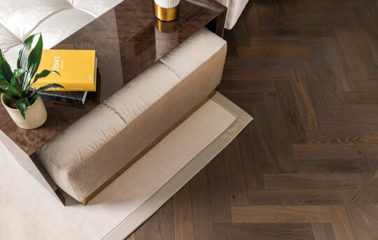 Espresso Herringbone overhead image with couch, rug and table with plank and book