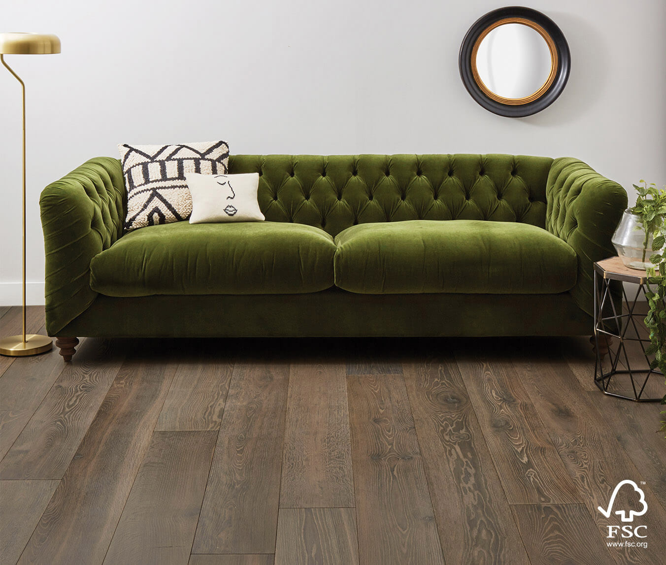 Tolland Oak Plank flooring set against a green couch, side table, floor lamp and mirror