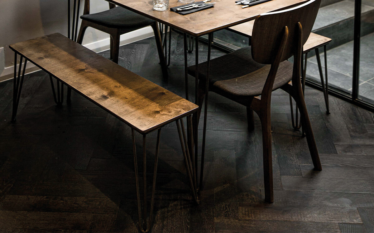 A clos up of the wooden tables and chairs set against our black Ebony superwide parquet floor