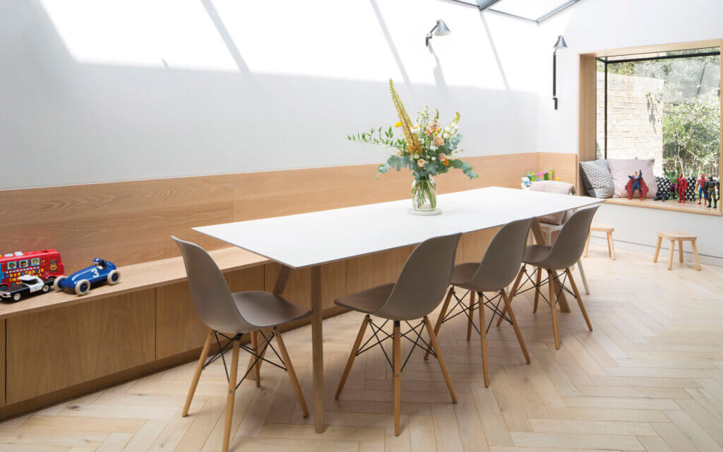 santi herringbone, strada collection. Herringbone floor laid in a kitchen with white table and grey chairs.