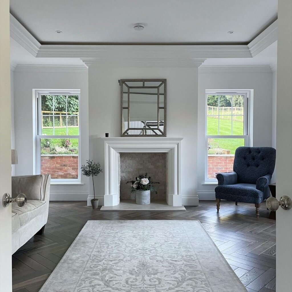 Tolland Herringbone room shot; showing blue chair, cream sofa, fireplace