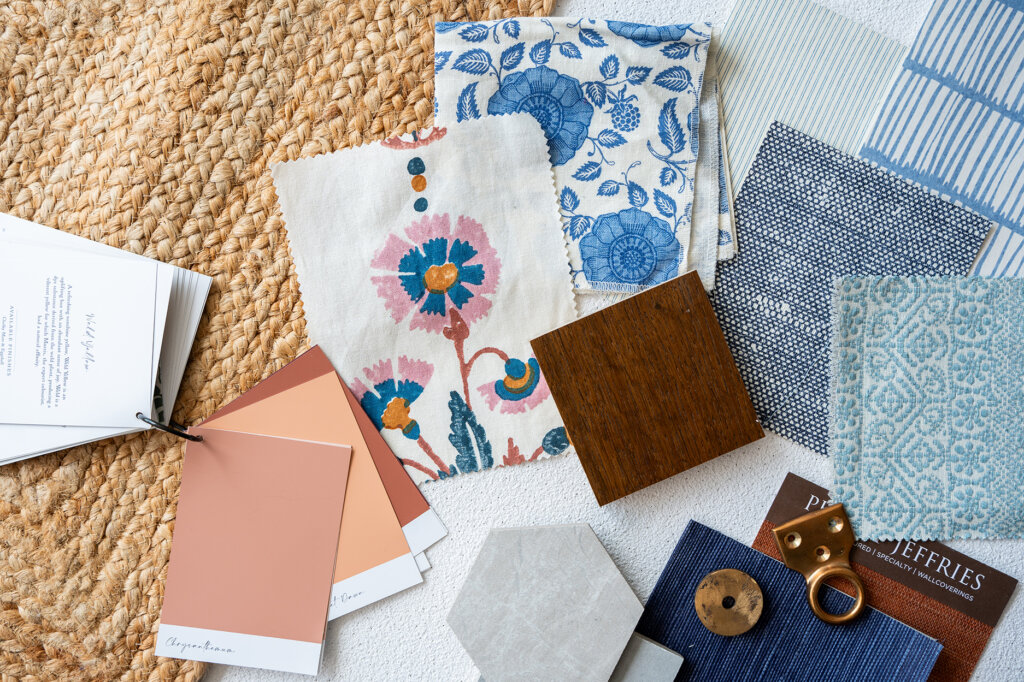 Layered samples of flooring, soft furnishings and paint swatches on a moodboard